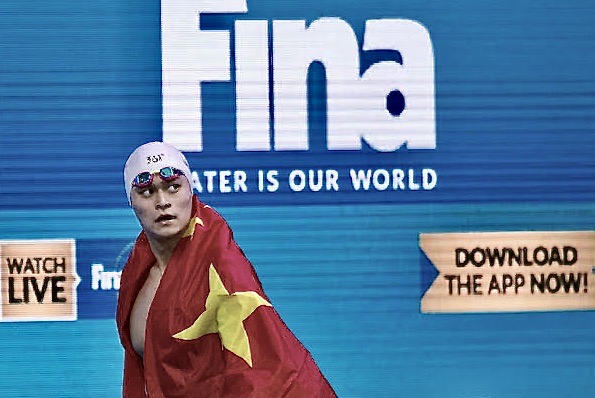 Sun Yang walks past a FINA banner at the 2017 World Championships - by Patrick B. Kraemer